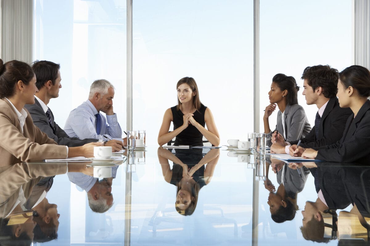 Group Of Business People Having Board Meeting Around Glass Table