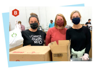 Beehive staff volunteering packing food at a nonprofit.