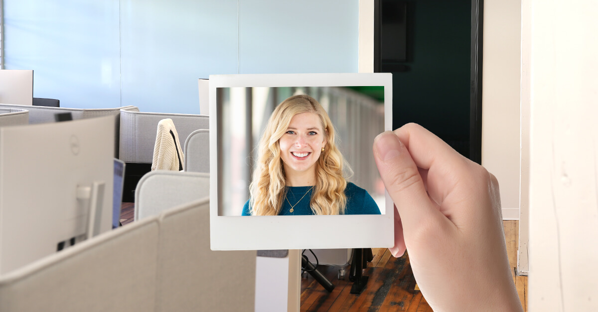 hand holding photo frame on isolated white with clipping path of Amy Hahn. Beehive office space in the background.