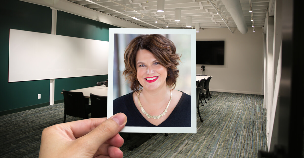 hand holding photo frame on isolated white with clipping path of Nicki Gibbs. Beehive meeting room in the background.